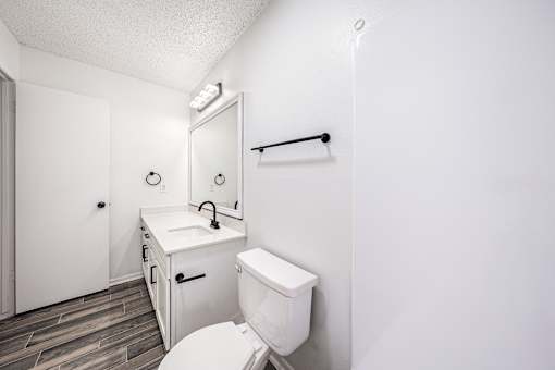 A white toilet sits next to a sink in a small bathroom.