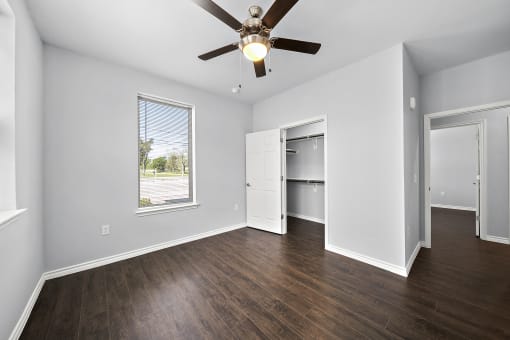 Empty bedroom with hardwood floors and window at The Aurea Apartments, Texas