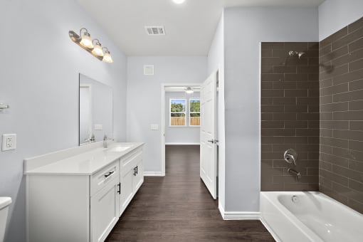Master bathroom with double vanity and tiled shower at The Aurea Apartments, Houston, Texas