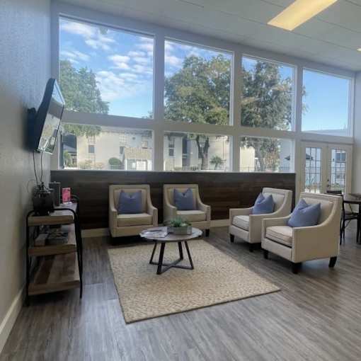 A waiting room with a view of the outside through the windows.