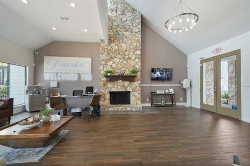A living room with a stone fireplace and a flat screen TV mounted on the wall.