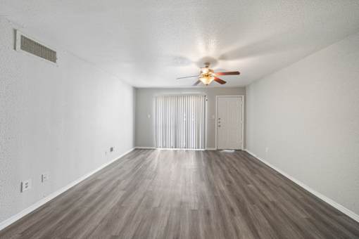 A room with a ceiling fan and a sliding door.