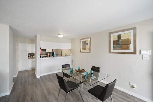 A dining room with a glass table and chairs.