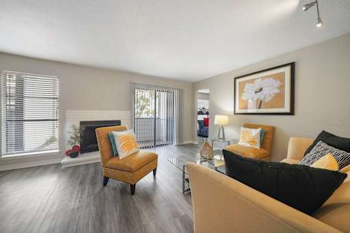 A living room with a yellow chair and a black couch.