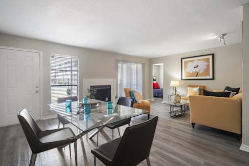 A modern dining room with a glass table and chairs.