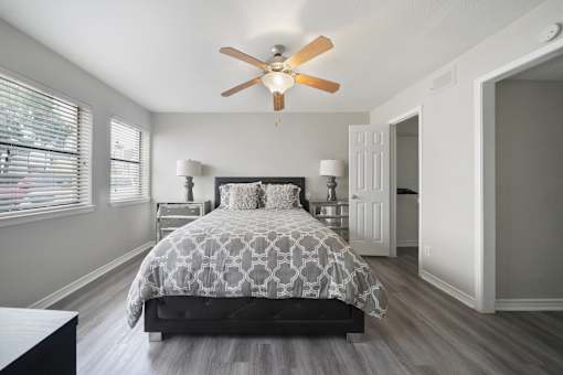 A bedroom with a bed, dresser, and a ceiling fan.