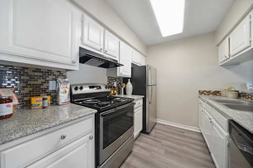 A kitchen with white cabinets and a stainless steel stove.