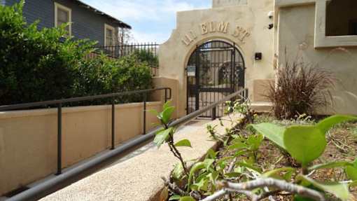 A stone wall with a metal railing and a gate with the word "Pellem" on it.