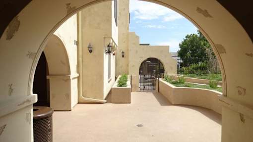 A courtyard with arches and a gate.