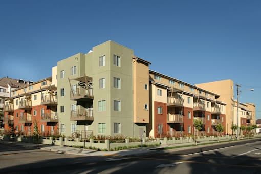 Apartment buildings with balconies line a street.