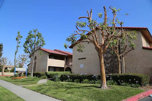 A building with a red roof and a tree in front of it.