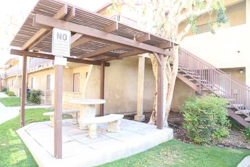 A patio with a bench and a sign that says "NO".