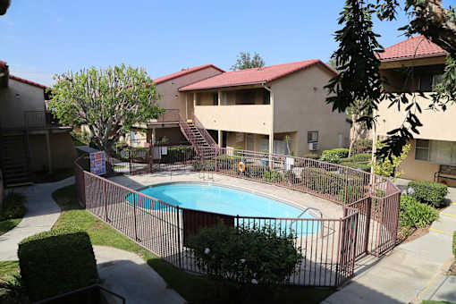 A pool surrounded by a fence in a residential area.
