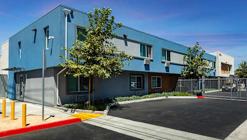 A blue building with a parking lot in front.
