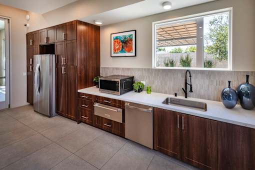 A modern kitchen with a refrigerator, sink, and cabinets.