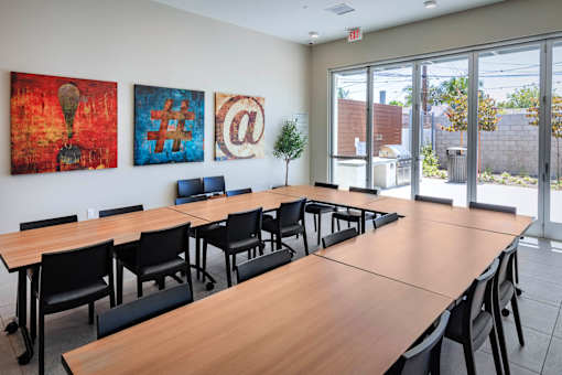 A conference room with a long table and chairs, and three artworks on the wall.