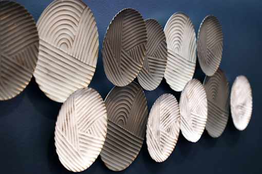 A series of circular objects with a pattern of lines are displayed against a dark background.