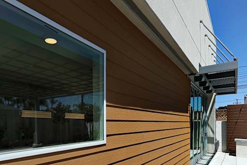 A modern house with a wooden exterior and a glass window.