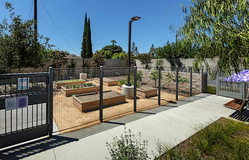 A garden with a fence and a sign on it.