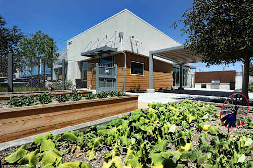 A building with a brown roof and a white wall with a black awning.