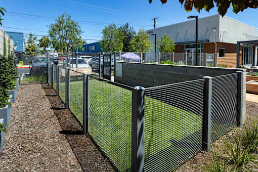 A long metal fence runs along a gravel path.