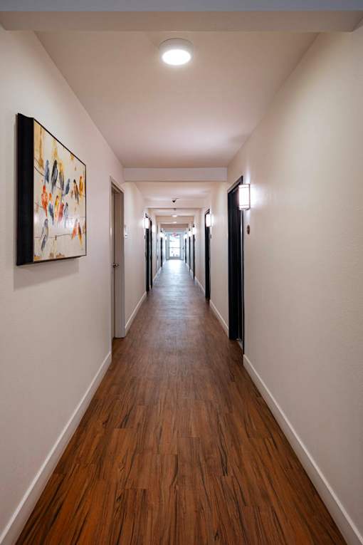 A long hallway with a painting on the wall.