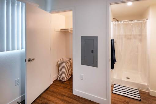 A bathroom with a white door, a white towel rack, and a white shower curtain.