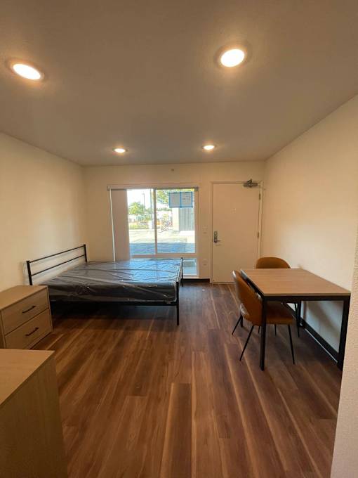 A bedroom with a bed, desk, and chair.