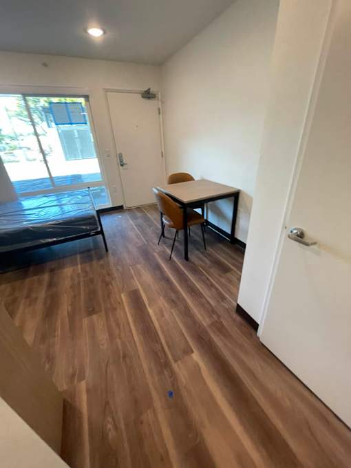 A room with a wooden floor and a table with two chairs.