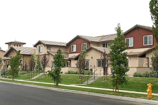 A row of houses with a yellow fire hydrant in front of them.