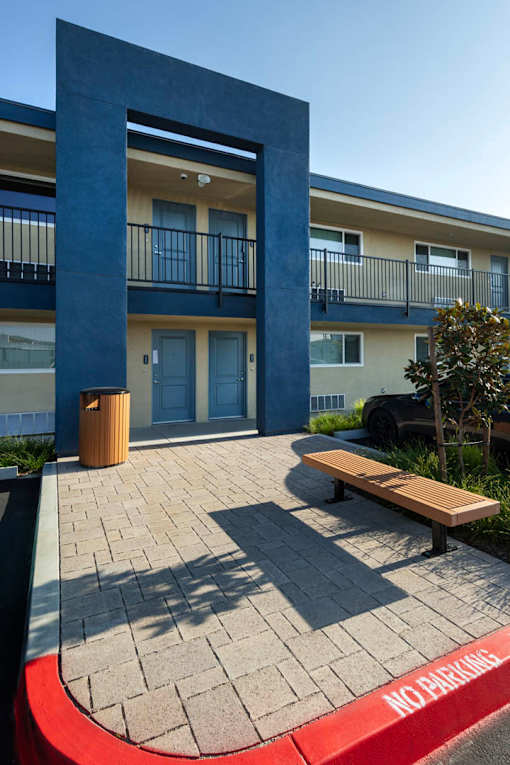 A building with a blue column and a bench in front of it.