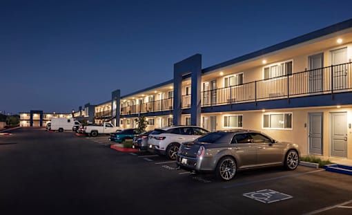 A parking lot with cars and a building in the background.