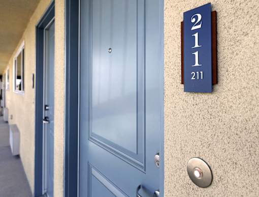 A blue door with a number 211 on the wall above it.
