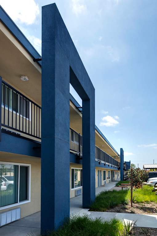 A blue building with a large blue pillar in front.