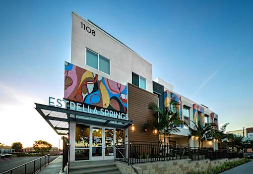 A modern building with a colorful mural on the side and the name "Estrella Springs" on the front.