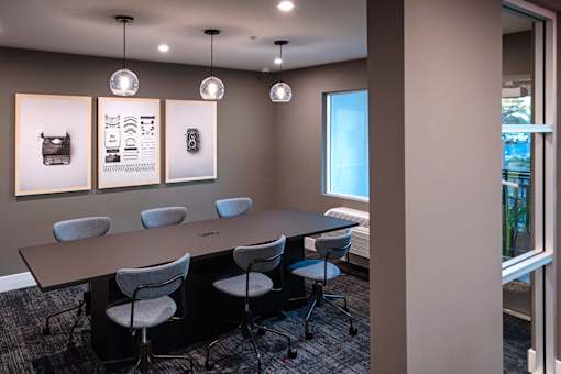 A conference room with a long table and chairs.