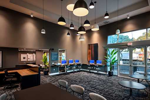 A modern office space with a reception desk, chairs, and computers.