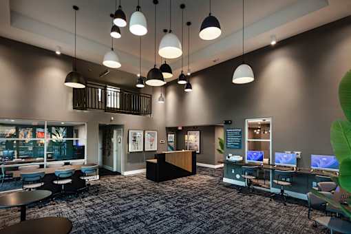 A modern office space with a reception desk and multiple workstations.