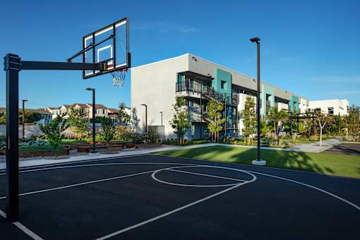 A basketball court is located in front of a modern building.