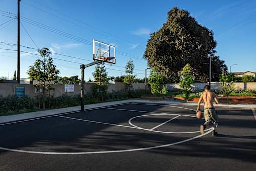 A man is playing basketball on an outdoor court.