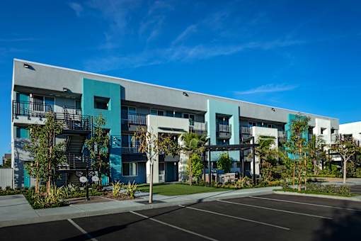 A modern building with a parking lot in front.