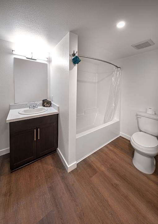 A white bathroom with a toilet, sink, and a shower curtain.