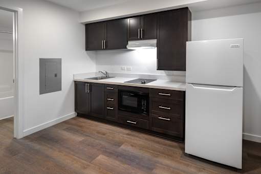 A kitchen with brown cabinets and a white fridge.