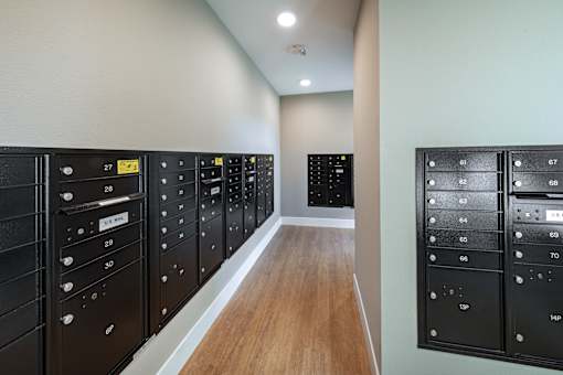 A long hallway with a series of black panels on the wall with numbers and letters on them.