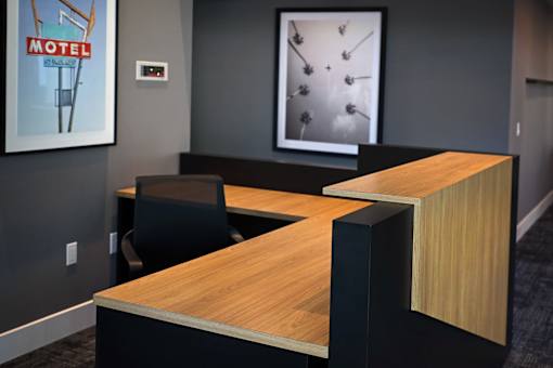 A modern office with a wooden desk and a framed picture of a motel sign.