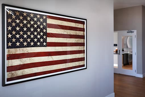 A large American flag is hanging on a wall in a room.