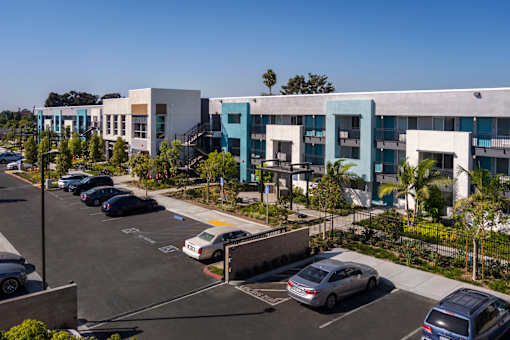 A parking lot with cars and a building in the background.