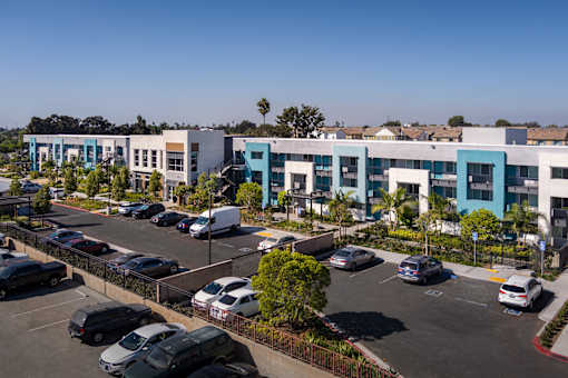 A parking lot with cars and a building in the background.