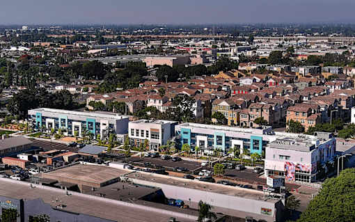 A cityscape with buildings and a parking lot.