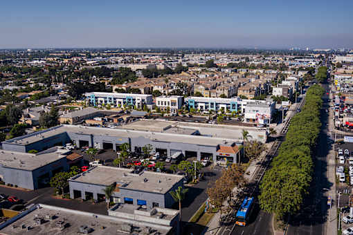 A large industrial building complex with a parking lot in front.